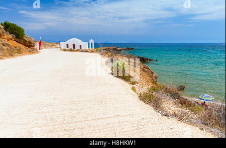 Paysage côtier de l'île de Zakynthos, Grèce. Route le long de la plage d''Agios Nikolaos. Petite église orthodoxe blanc Banque D'Images