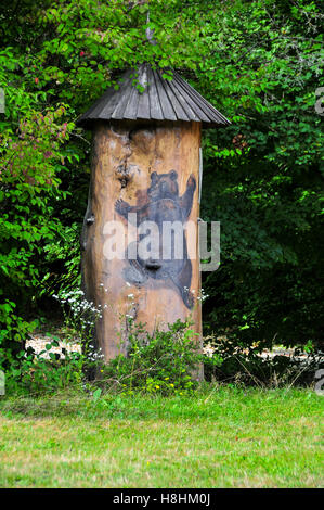 Colorés et traditionnels en bois pittoresque ruche faite de tronc d'arbre et un ours peint en Slovénie. Les ruches sont peints à Banque D'Images