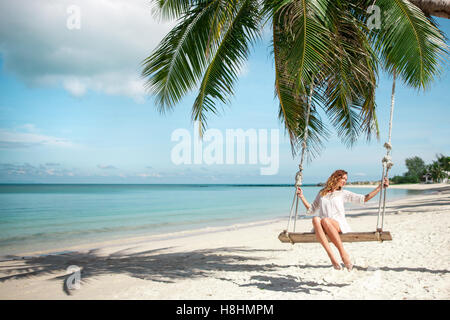 Belle femme Swinging on Beach Banque D'Images