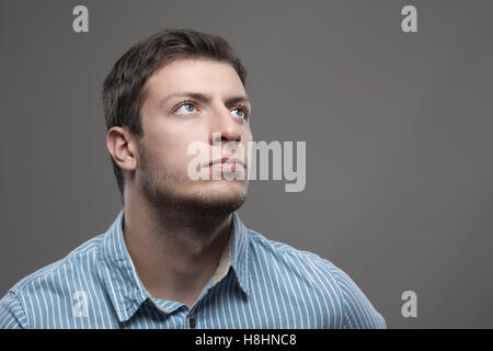 Portrait de jeunes Moody pdg visionnaire dans blue shirt looking up Banque D'Images