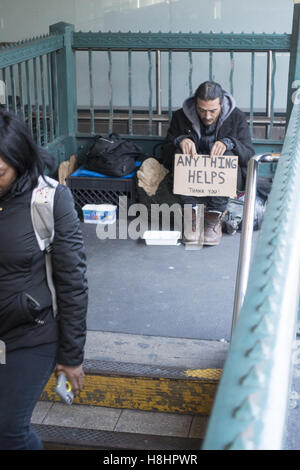 Sans-abri tend la main pour obtenir de l'aide à une entrée de la station de métro sur Broadway dans le quartier Soho de Manhattan, New York. Banque D'Images