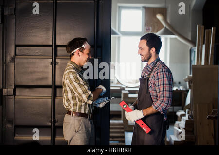 Architectes mâles shaking hands at construction site Banque D'Images