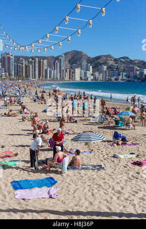 Plage de Benidorm, alicante province, Costa Blanca, Espagne. tous les groupes d'âge à la retraite des aînés savons de soleil en flânant à pied se reposer près de la mer Banque D'Images