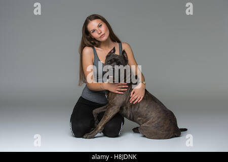 Belle fille avec Stafford Terrier gris Banque D'Images