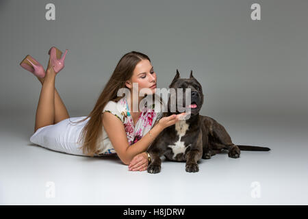 Belle fille avec Stafford Terrier gris Banque D'Images