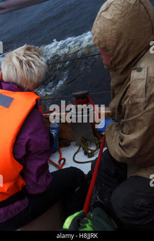 Sialors sur le bateau faisant un nœud Banque D'Images