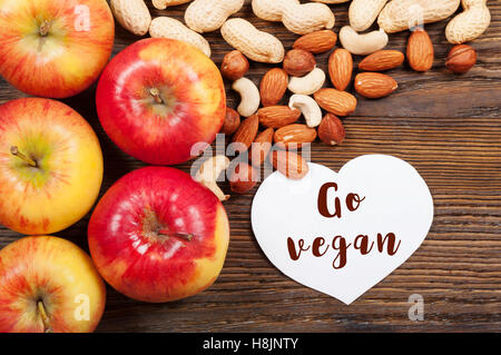 Pommes rouges bien mûrs et de noix sur un fond de bois. Vue d'en haut. Concept vegan. Banque D'Images