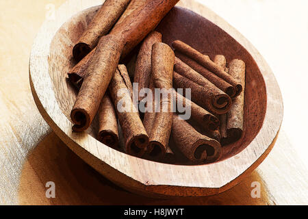 Cannelle (Cinnamomum verum) bâtons dans un bol en bois Banque D'Images