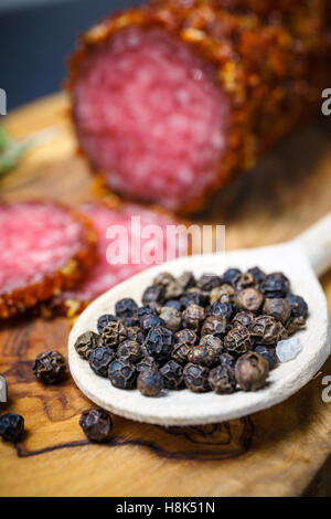 Salami séché en croûte rouge moulu sur fond sombre Banque D'Images