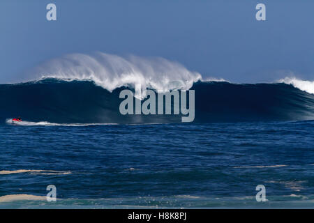 Remorquer à surfers sur le Wave runners surf de grosses vagues sur la côte nord d'Oahu Banque D'Images