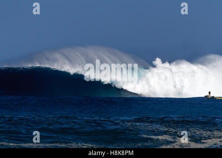 Remorquer à surfers sur le Wave runners surf de grosses vagues sur la côte nord d'Oahu Banque D'Images