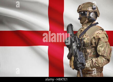 Soldat dans helmet holding machine gun avec drapeau national sur l'arrière-plan - Angleterre Banque D'Images