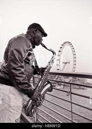 Artiste de rue, musicien ambulant jouer du jazz saxophone sur Jubilee Bridge at Dusk avec Tamise et London Eye en arrière-plan London UK Banque D'Images