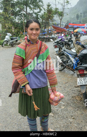 Hmong fleur fille avec un pied de poulet frit, Coc Ly marché près de Sa Pa, Vietnam du Nord Banque D'Images
