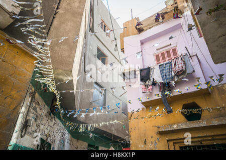 Le Caire, Égypte. Regarde les immeubles à appartements avec lave en train de sécher dehors dans une ruelle près de la piscine en plein air bazar/ brocante mar Banque D'Images