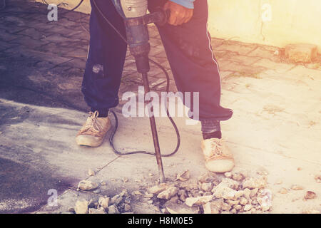 Close up homme travailleur plancher de béton de ciment forage mason avec la machine Banque D'Images