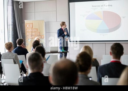 Businessman explaining graphique pour l'auditoire en salle de séminaire Banque D'Images