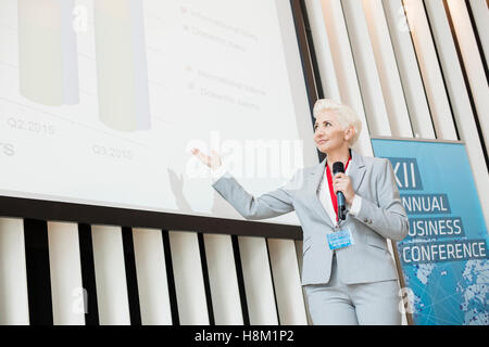 Businesswoman giving presentation sur l'écran de projection au centre des congrès Banque D'Images