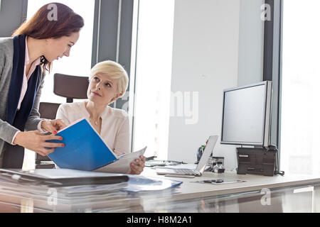 Businesswomen discussing sur nouveau projet at desk in office Banque D'Images