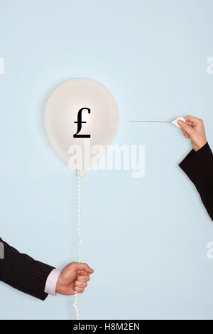 Cropped mains tenant l'aiguille et ballon popping avec symbole Banque D'Images