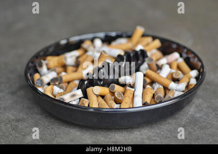 Cendrier plein de cigarettes sur la table, close-up Banque D'Images