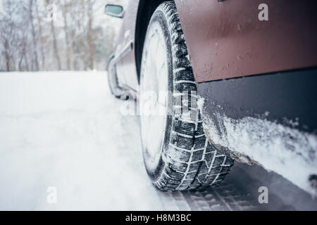 Voiture avec des pneus d'hiver sur la route enneigée, image flou artistique Banque D'Images