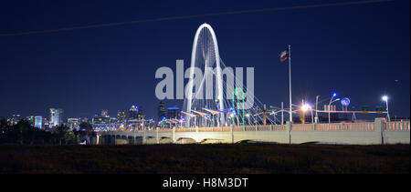 Le Margaret Hunt Hill bridge est illuminée la nuit et offre des vues spectaculaires sur les toits de Dallas. Banque D'Images