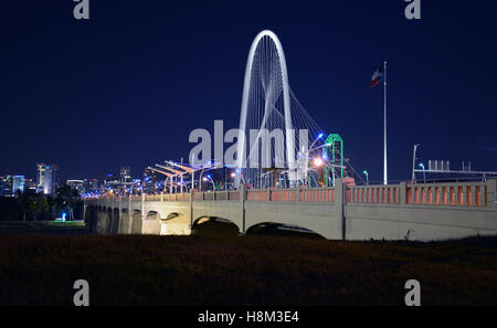 Le Margaret Hunt Hill bridge est illuminée la nuit et offre des vues spectaculaires sur les toits de Dallas. Banque D'Images