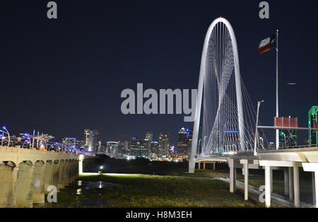 Le Margaret Hunt Hill bridge est illuminée la nuit et offre des vues spectaculaires sur les toits de Dallas. Banque D'Images