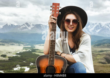 Belle fille avec des montagnes de guitare Banque D'Images