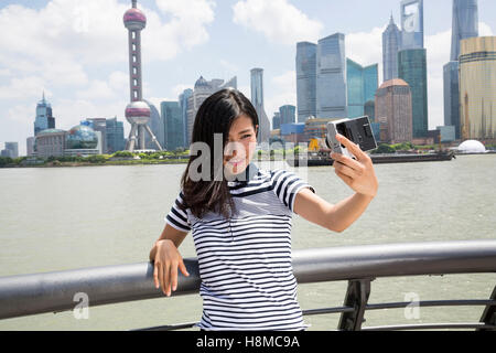 Femme souriante en tenant debout selfies en fustigeant l'horizon de Pudong Banque D'Images