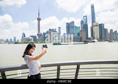 Jeune femme en tenant debout selfies en fustigeant l'horizon de Pudong Banque D'Images