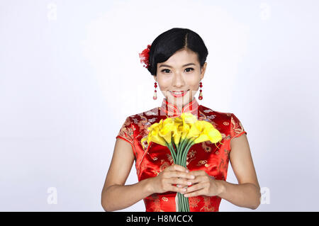 Chinois jolie jeune femme tenant un bouquet de jonquilles jaune Banque D'Images