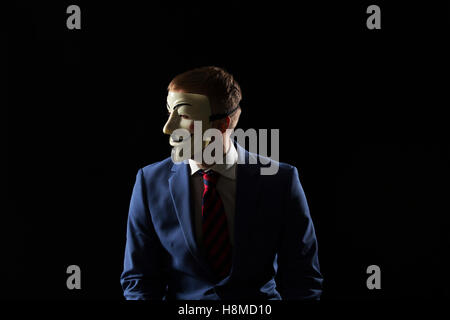 L'homme d'affaires sous le masque déguisement être anonyme et dire qu'il est un hacker ou anarchistes Banque D'Images