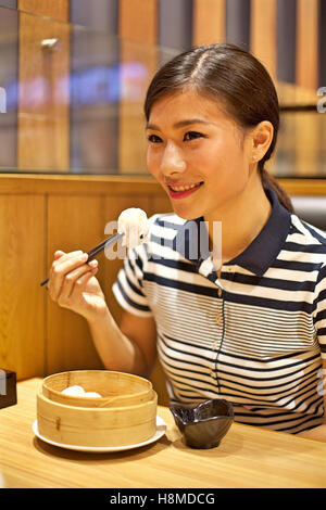 Femme chinoise dumpling vapeur manger dans restaurant Banque D'Images