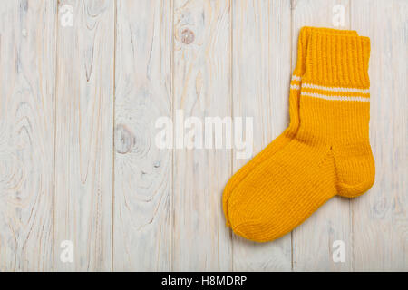 Des chaussettes en laine tricotées voyant jaune sur le fond en bois. Banque D'Images
