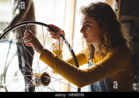 L'examen de mécanicien d'une roue de vélo Banque D'Images