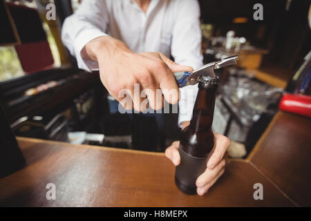 Close-up du barman de l'ouverture d'une bouteille de bière Banque D'Images