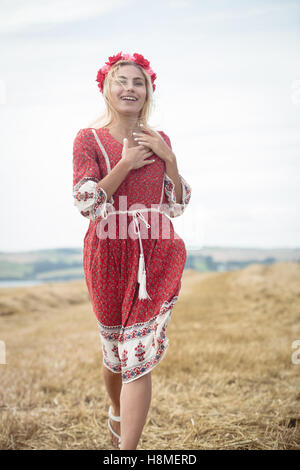 Blonde woman walking in field Banque D'Images