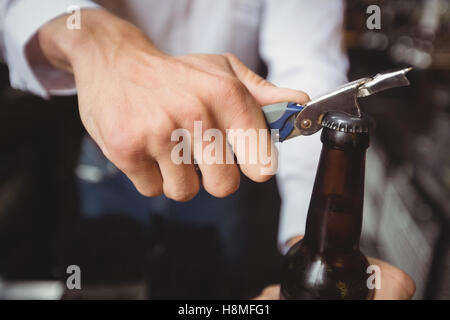 Close-up du barman de l'ouverture d'une bouteille de bière Banque D'Images