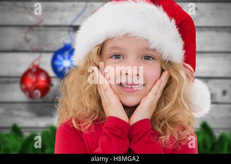 Little girl in santa hat smiling at camera Banque D'Images