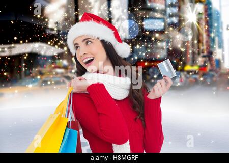 Cheerful woman in santa costume holding Shopping bag et une carte de crédit Banque D'Images