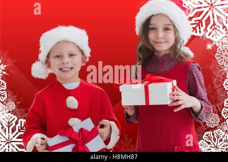 Deux enfants heureux à santa costume holding a Christmas Gift Banque D'Images