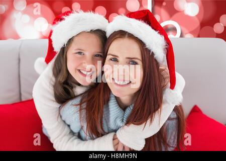 Happy mother and daughter in santa claus hats Banque D'Images