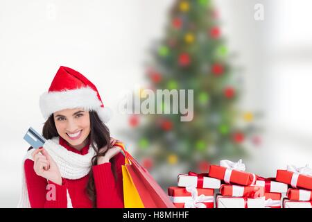 Beautiful woman in santa hat holding shopping bags Banque D'Images