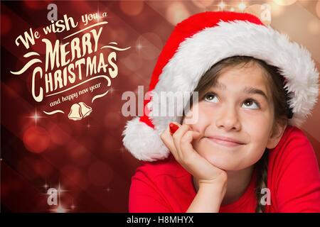 Thoughtful girl in santa hat with hand on chin Banque D'Images