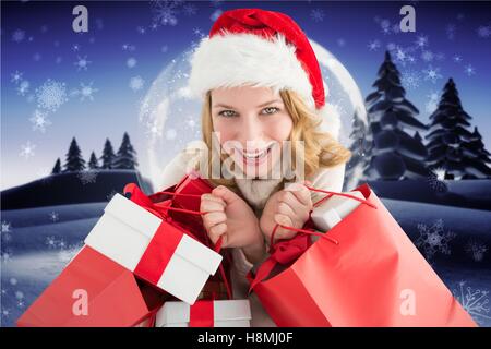 Belle femme excité à santa hat holding sacs cadeaux Banque D'Images