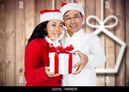 Heureux couple in santa hat holding christmas gift Banque D'Images