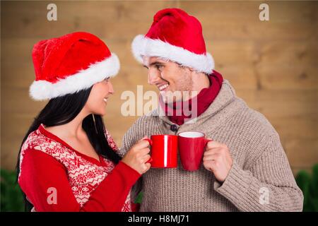 Couple in santa hat toasting with coffee mug Banque D'Images