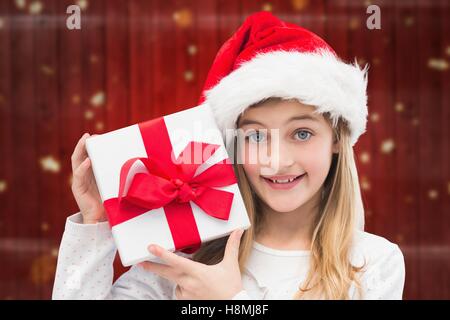 Girl in santa hat holding christmas gifts Banque D'Images